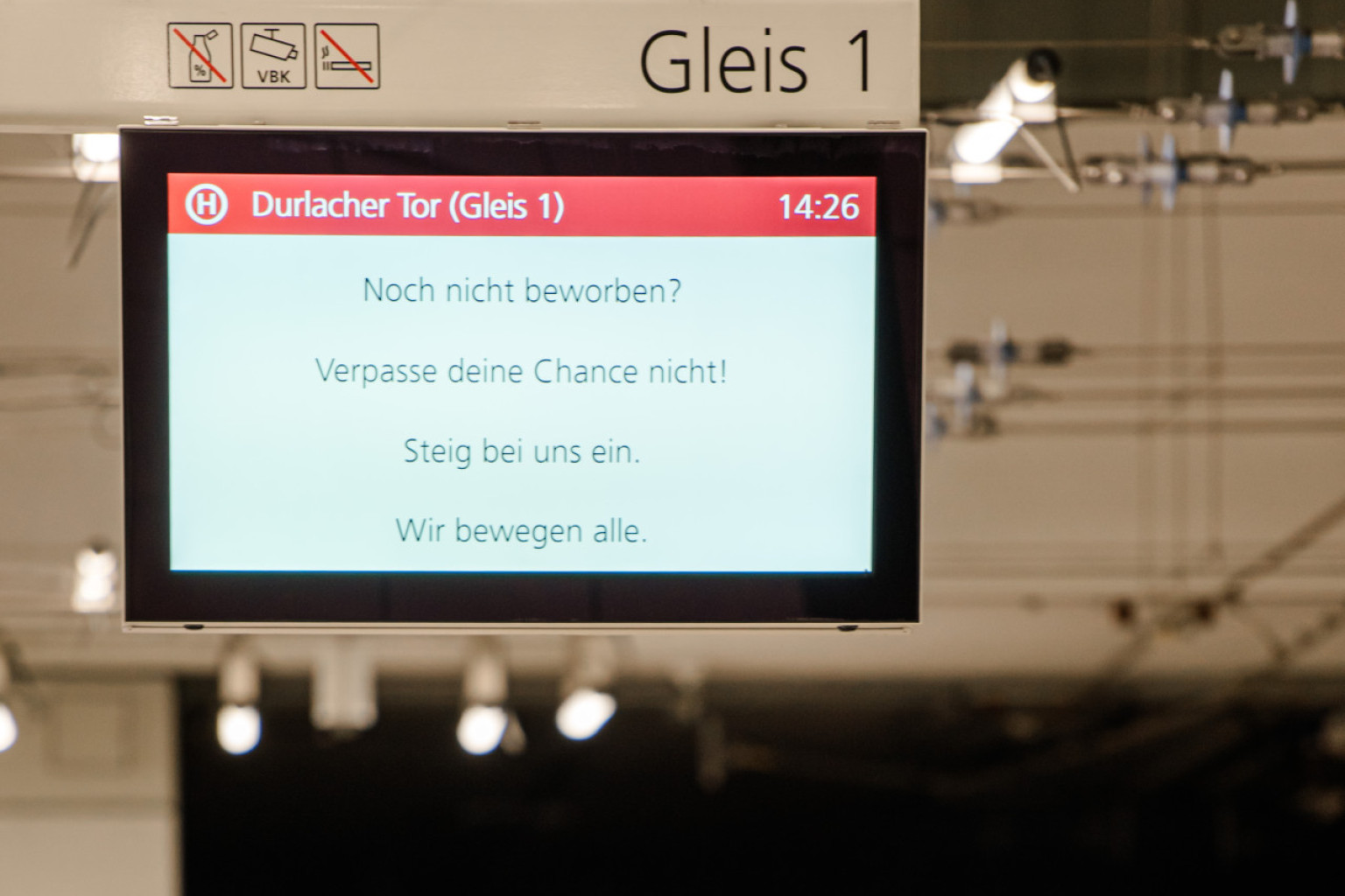 Ein Haltestellenmonitor auf dem Fahrgastinformationen eingeblendet sind mit dem Verweis sich bei uns zu bewerben.