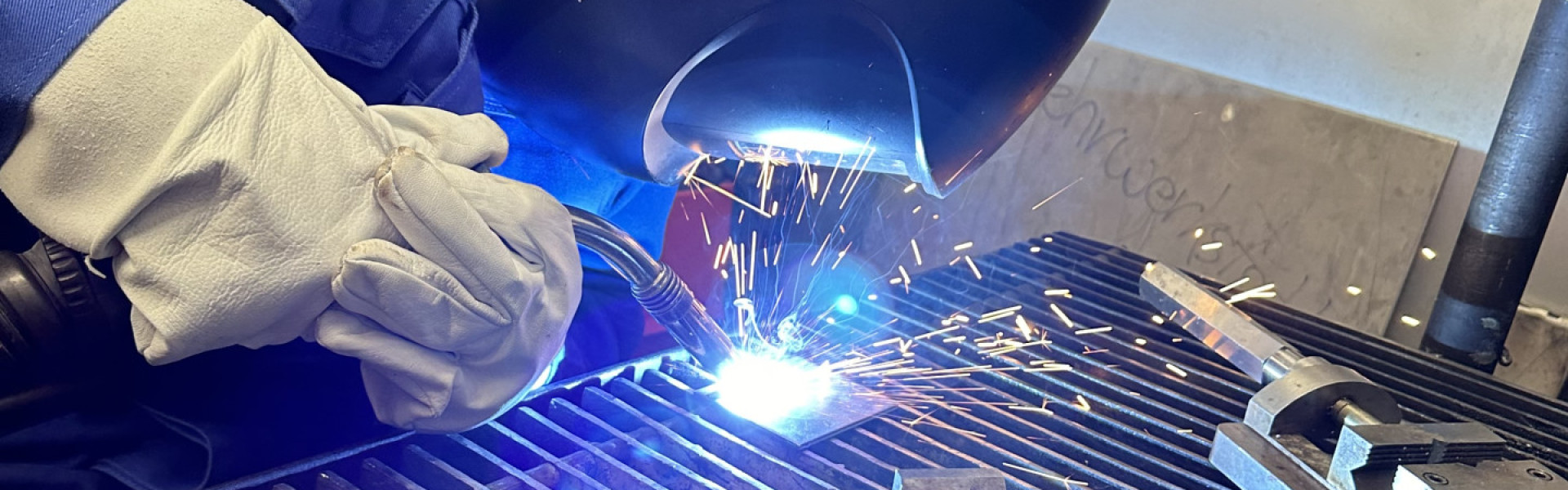 Ein Azubi schweißt mit Schutzausrüstung ein Bahnteil zusammen.
