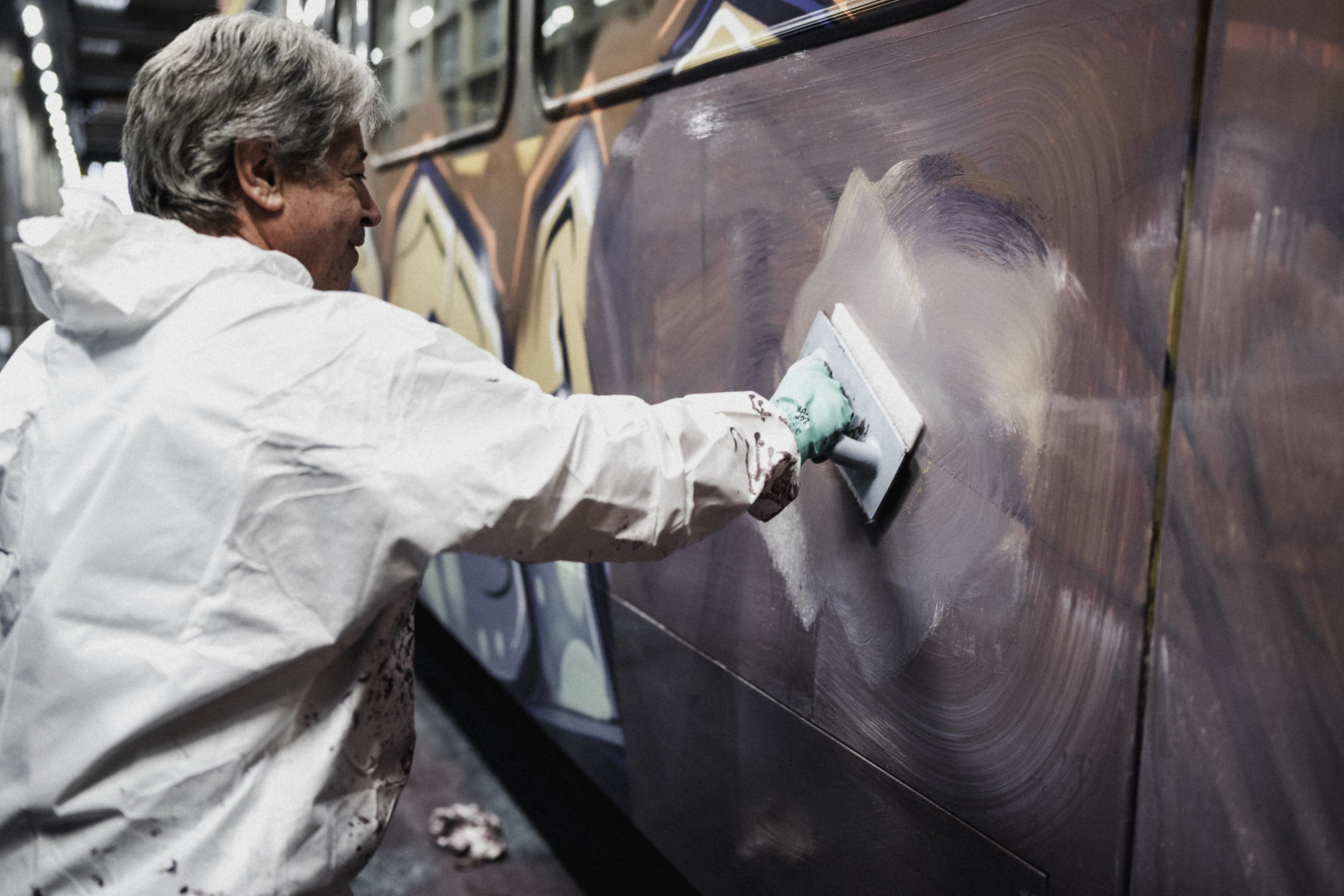 Ein Mitarbeiter streicht per Hand eine dreckige Bahn.